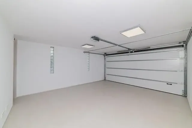 Garaje terminado con puerta seccional montada y solera de hormigón acabada.