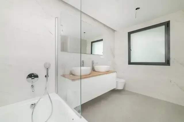 Baño en fase de remate, con bañera instalada y ventana de ventilación.