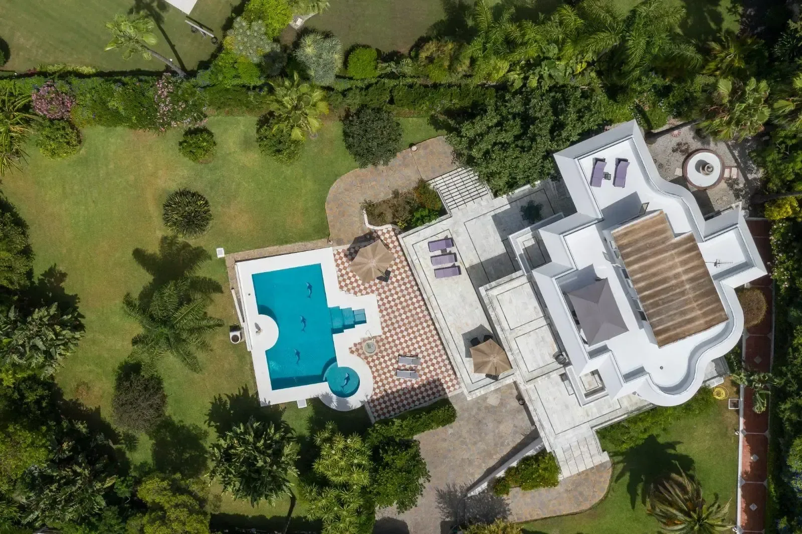 Vista aérea de la villa de Marbella, con la piscina, las terrazas escalonadas y el jardín rodeando la casa.